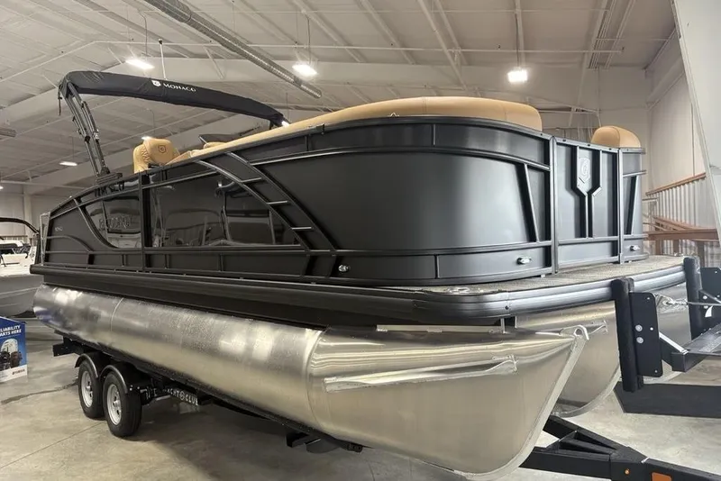 Slide: The Image of 2025 Godfrey AquaPatio 235 DFL pontoon boat displayed indoors on a trailer. - 2