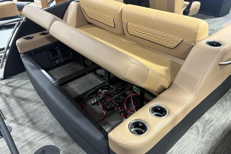 Slide: The Image of 2025 Godfrey AquaPatio 235 DFL boat interior with open storage compartment and cup holders. - 26