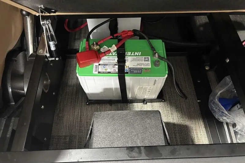 Slide: The Image of Battery compartment of 2025 Godfrey AquaPatio 235 DFL pontoon boat, featuring an Interstate battery. - 28