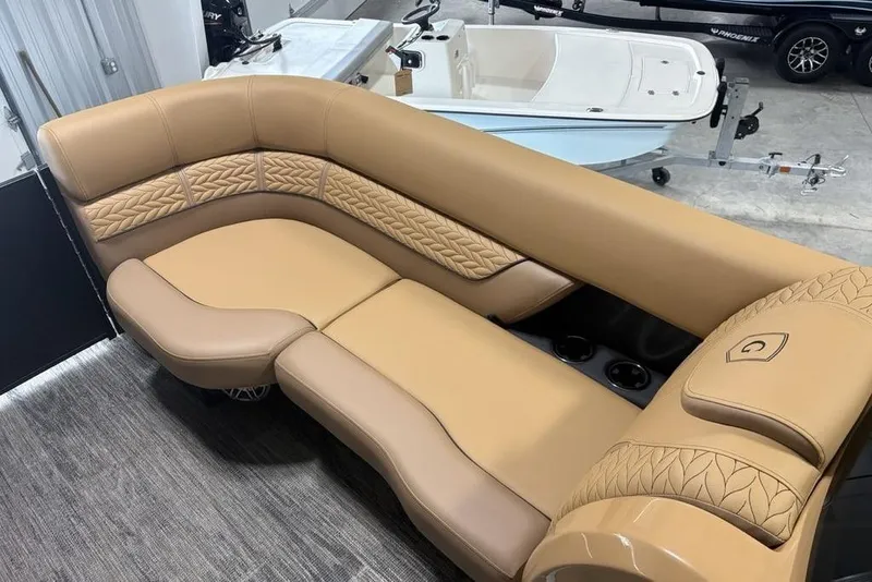 Slide: The Image of Luxurious tan seating on 2025 Godfrey AquaPatio 235 DFL boat, featuring elegant stitching and cup holders. - 3