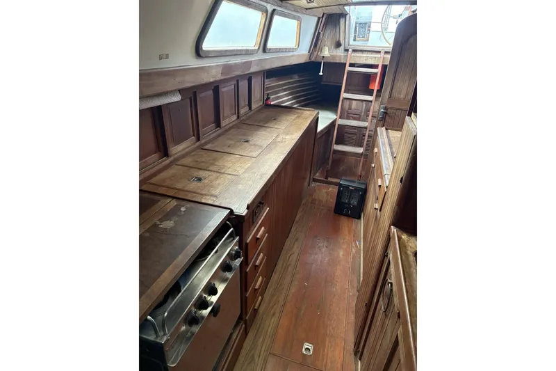 Slide: The Image of Engine components inside a 1980 Tanton sailboat, featuring filters and wiring on a wooden panel. - 11