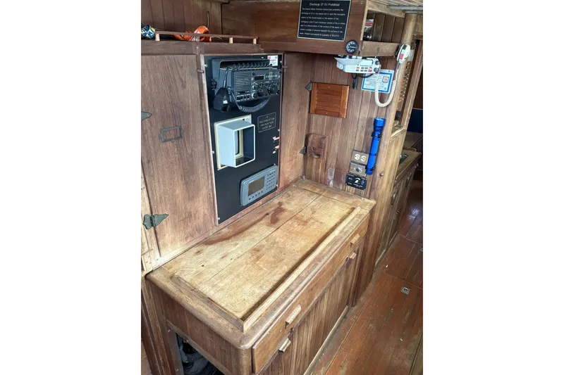 Slide: The Image of Interior of a 1980 Tanton Sailboat with wooden cabinetry and compact kitchen area. - 9