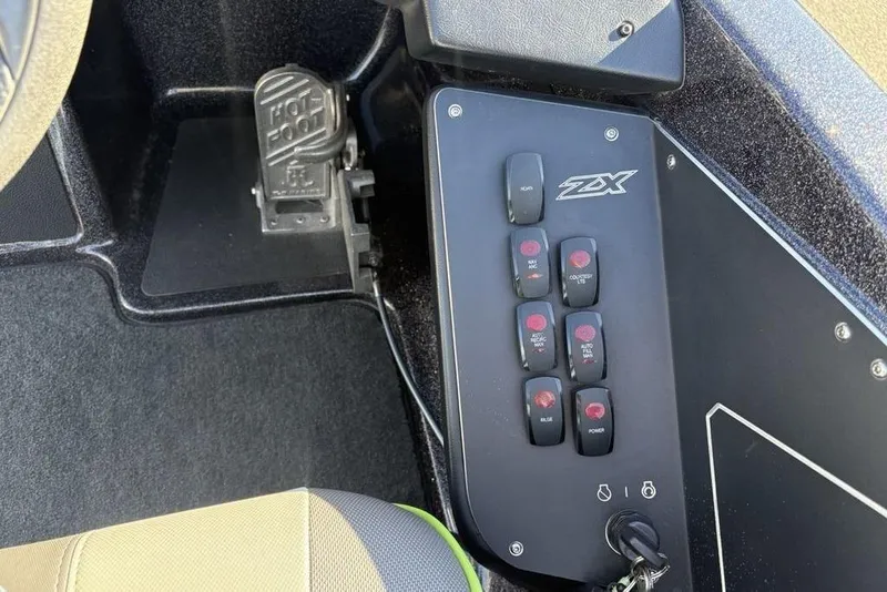 Slide: The Image of Control panel of a 2018 Skeeter ZX225 boat with switches and foot pedal. - 24