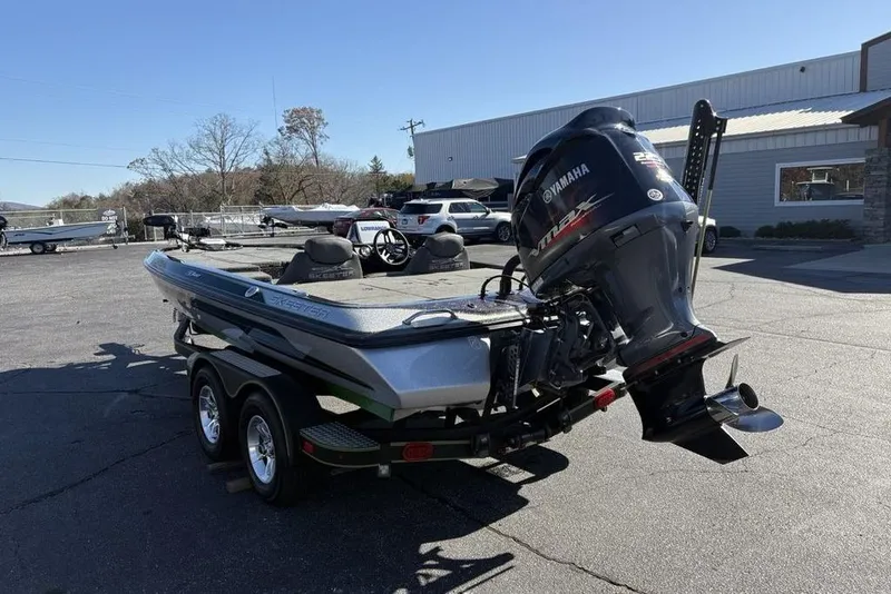 Slide: The Image of 2018 Skeeter ZX225 bass boat with Yamaha outboard motor on a trailer in a parking lot. - 3