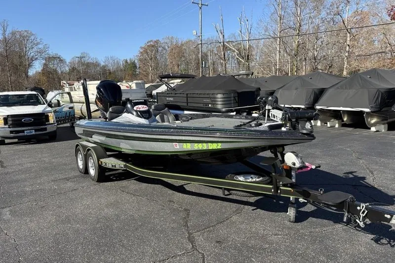 Slide: The Image of 2018 Skeeter ZX225 bass boat on trailer in parking lot, surrounded by vehicles and covered boats. - 4