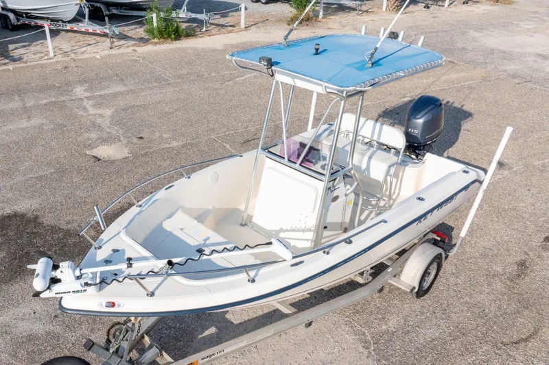 Slide: The Image of 2004 Key West 186 Center Console boat on trailer, featuring blue canopy and outboard motor. - 10