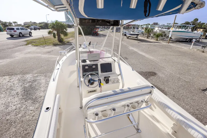 Slide: The Image of 2004 Key West 186 Center Console boat with blue canopy, parked near a marina. - 18