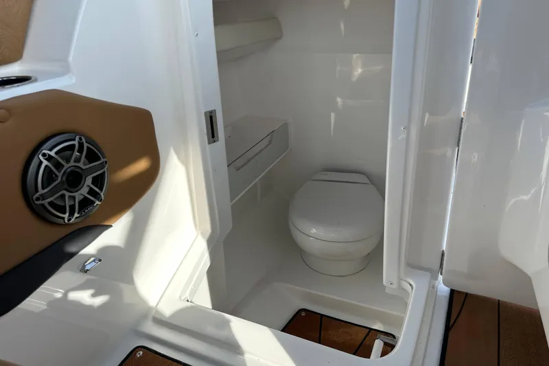 Slide: The Image of 2024 Hurricane SunDeck 2600 OB boat interior with toilet and speaker. - 12