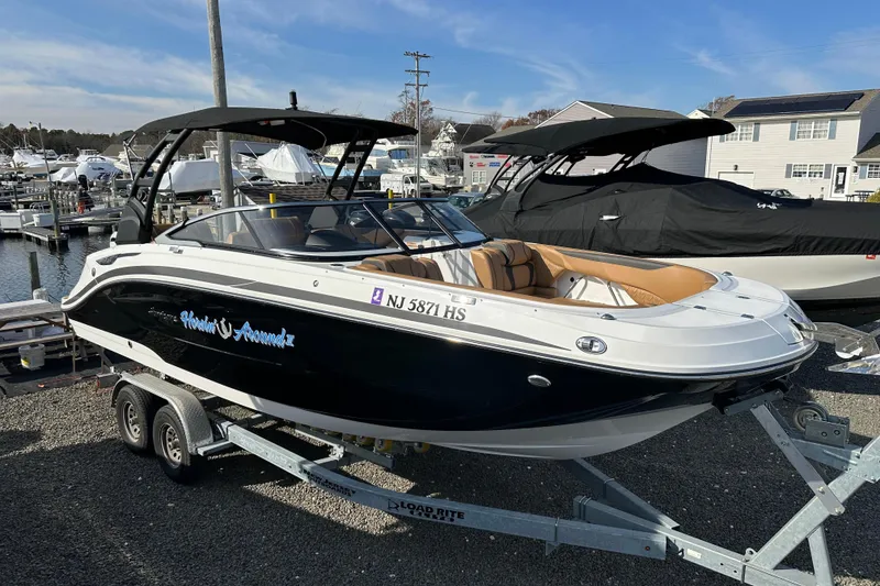 Slide: The Image of 2024 Hurricane SunDeck 2600 OB boat on trailer at marina, black and white design. - 19
