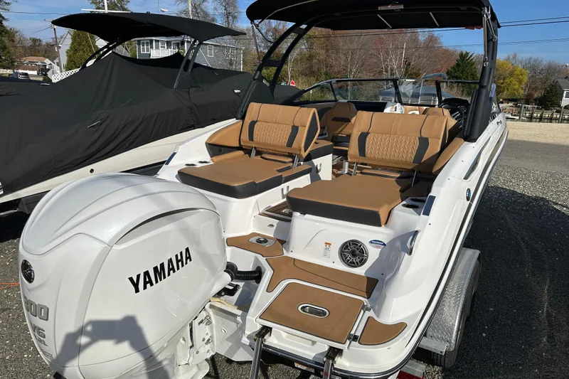 Slide: The Image of 2024 Hurricane SunDeck 2600 OB boat with Yamaha engine, featuring tan seating and sleek design. - 21
