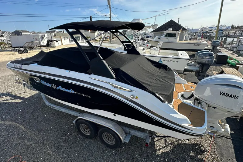 Slide: The Image of 2024 Hurricane SunDeck 2600 OB boat with Yamaha engine, covered and on a trailer. - 24