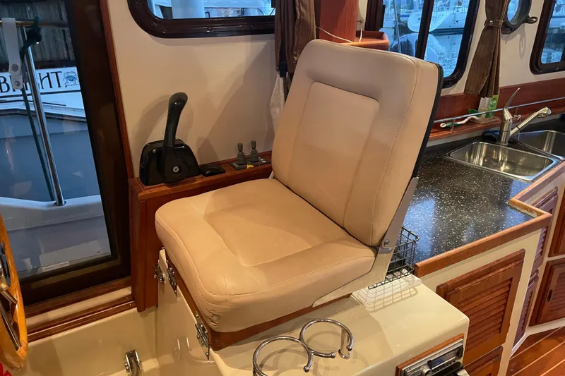 Slide: The Image of Captain's seat in 2010 Ranger Tugs R-29 boat interior, near helm and kitchen area. - 13