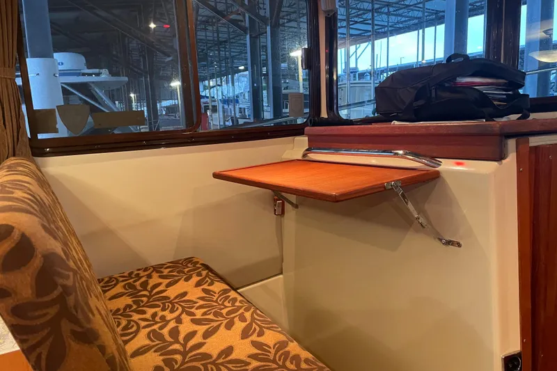 Slide: The Image of Interior of 2010 Ranger Tugs R-29 with foldable table and patterned seating. - 17