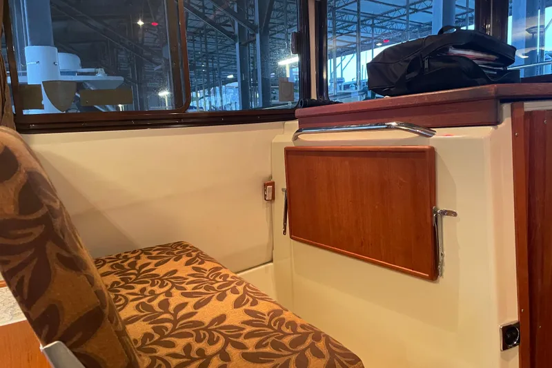 Slide: The Image of Interior of 2010 Ranger Tugs R-29 with patterned seating and wooden cabinetry. - 18