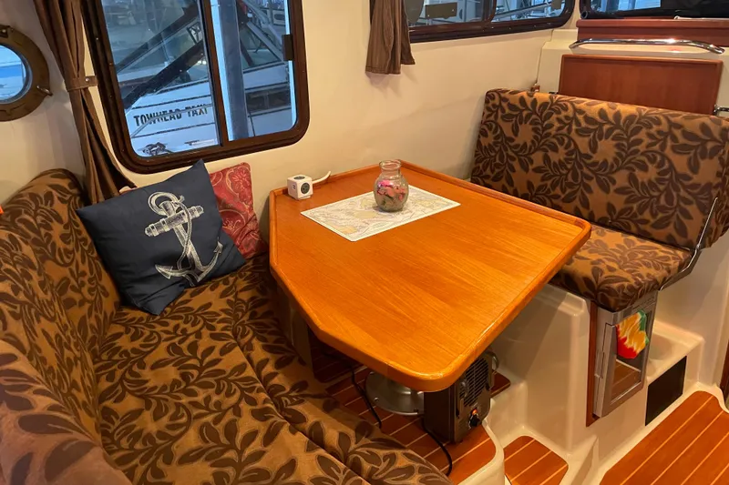 Slide: The Image of Cozy interior of 2010 Ranger Tugs R-29 with floral seating and wooden table. - 19