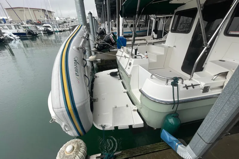 Slide: The Image of 2010 Ranger Tugs R-29 docked with inflatable boat, marina background. - 6