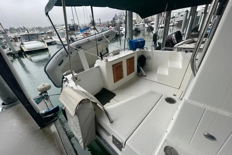 Slide: The Image of 2010 Ranger Tugs R-29 boat docked at marina, featuring spacious deck and seating area. - 7
