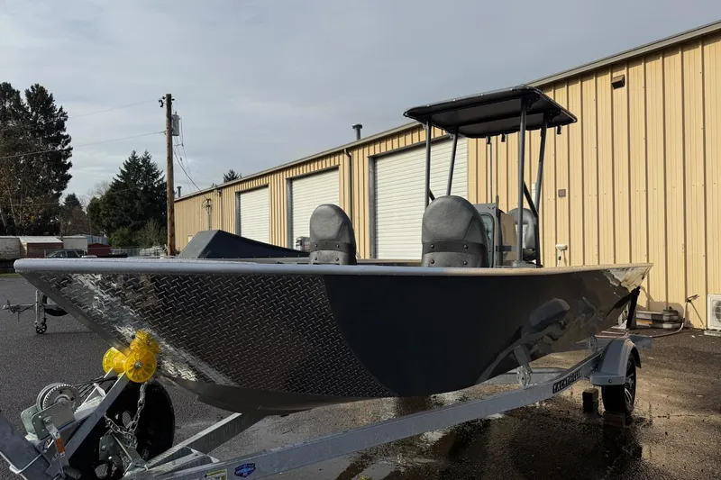 The Image of 2026 Fish Rite Angler 18 boat on trailer, parked near industrial building. - 1