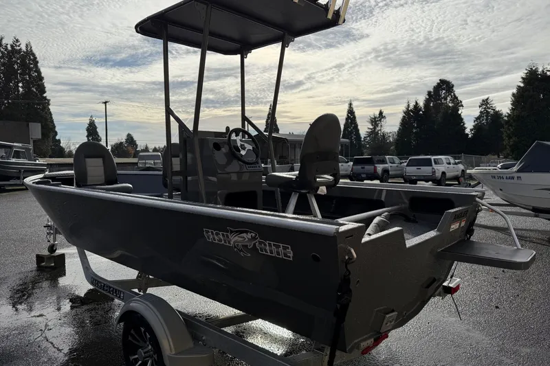 Slide: The Image of 2026 Fish Rite Angler 18 boat on trailer, parked outdoors under cloudy sky. - 3