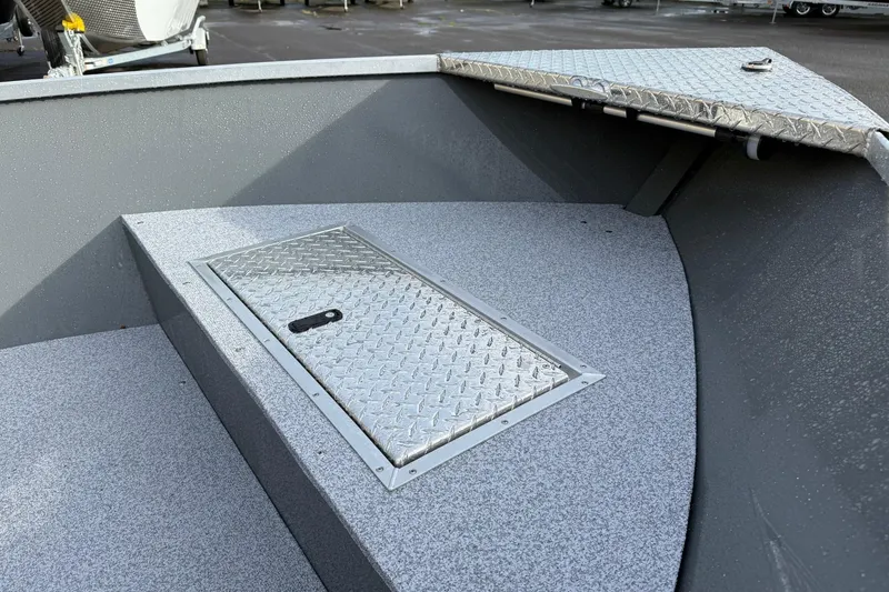 Slide: The Image of 2026 Fish Rite Angler 18 boat deck with storage compartment and diamond plate cover. - 7