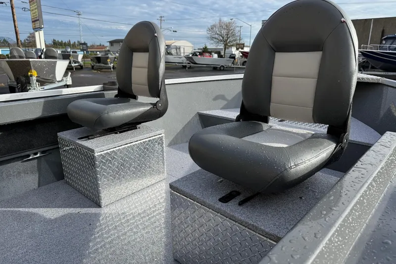 Slide: The Image of 2026 Fish Rite Angler 18 boat seats with diamond plate bases, outdoor setting. - 9