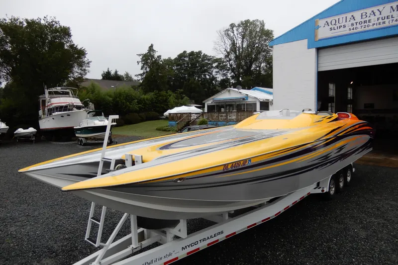 Slide: The Image of 2008 Nor-Tech 3600 Supercat powerboat on trailer at marina, featuring sleek yellow design. - 12