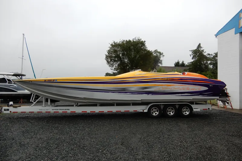 Slide: The Image of 2008 Nor-Tech 3600 Supercat powerboat on trailer, vibrant yellow and purple design. - 13