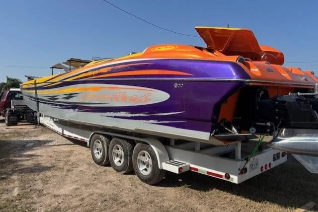 Slide: The Image of 2008 Nor-Tech 3600 Supercat powerboat with vibrant orange and purple design on a trailer. - 3