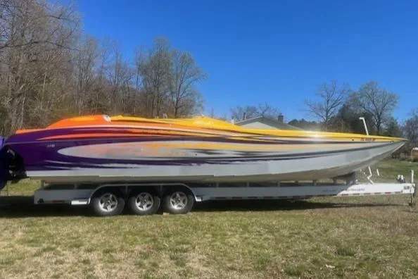 Slide: The Image of 2008 Nor-Tech 3600 Supercat boat with vibrant orange and purple design on a trailer. - 8