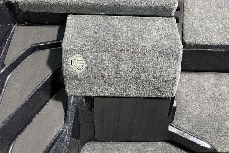 Slide: The Image of Carpeted interior detail of a 2026 Skeeter ZXE21 boat, featuring a metal latch. - 17