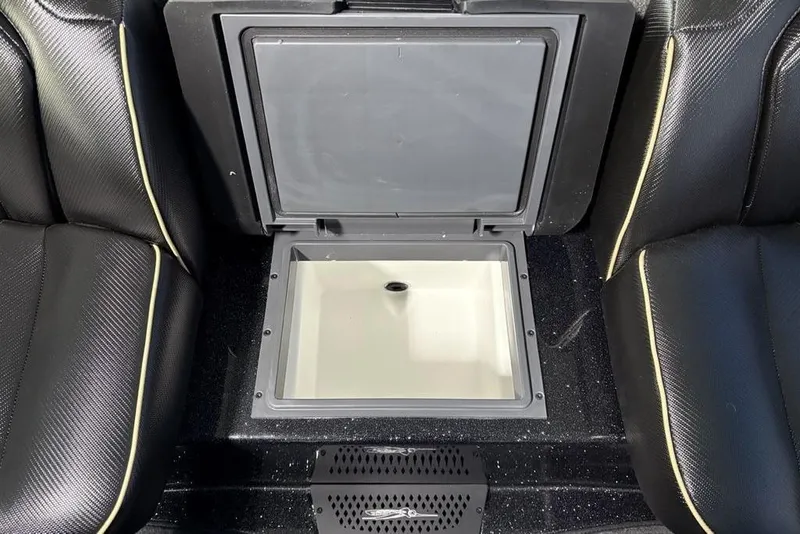 Slide: The Image of 2026 Skeeter ZXE21 boat interior with open storage compartment between black seats. - 18