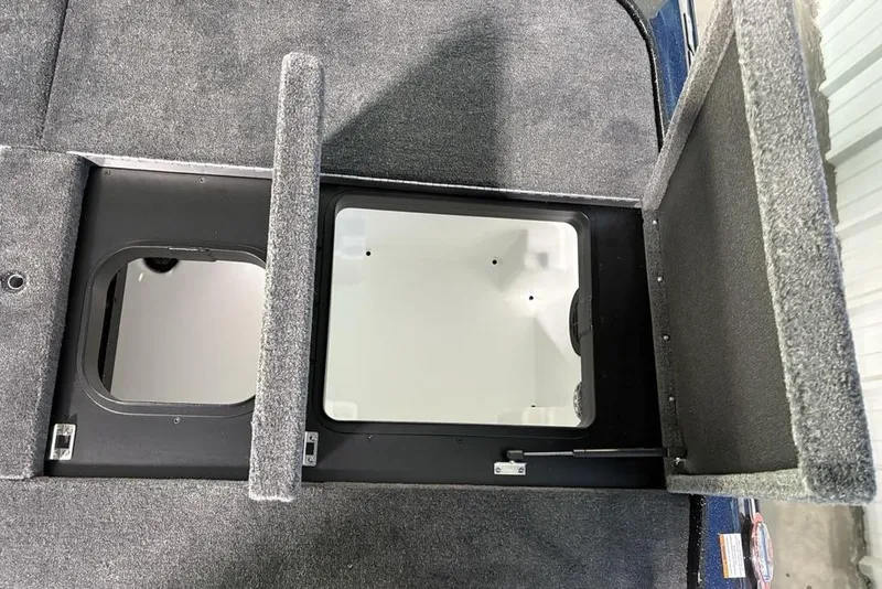 Slide: The Image of 2026 Skeeter ZXE21 boat storage compartments with open lids, showcasing interior space. - 33