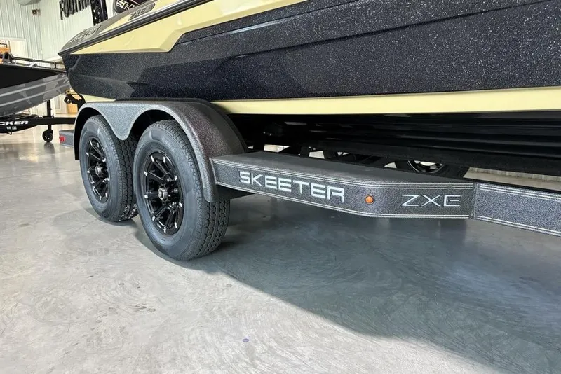 Slide: The Image of 2026 Skeeter ZXE21 boat trailer with dual black wheels in a showroom. - 8