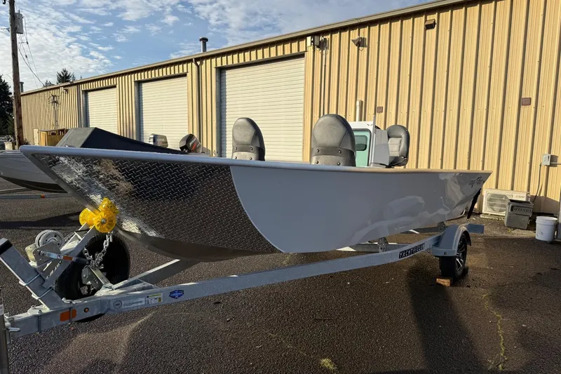 The Image of 2026 Fish Rite Angler 18 boat on trailer, parked outside industrial building. - 1