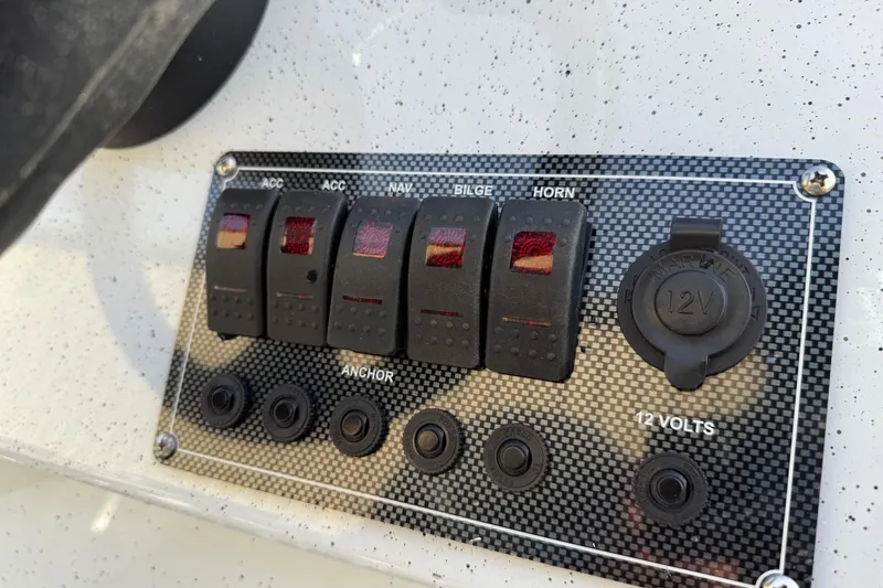 Slide: The Image of Control panel of 2026 Fish Rite Angler 18 boat with switches and 12V outlet. - 13