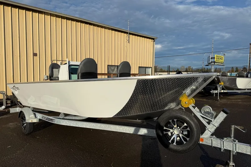 Slide: The Image of 2026 Fish Rite Angler 18 boat on trailer, parked outside a warehouse. - 6