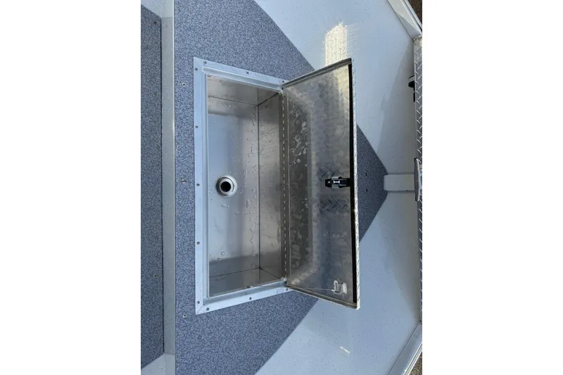 Slide: The Image of Open storage compartment on 2026 Fish Rite Angler 18 boat, featuring a metallic interior. - 7