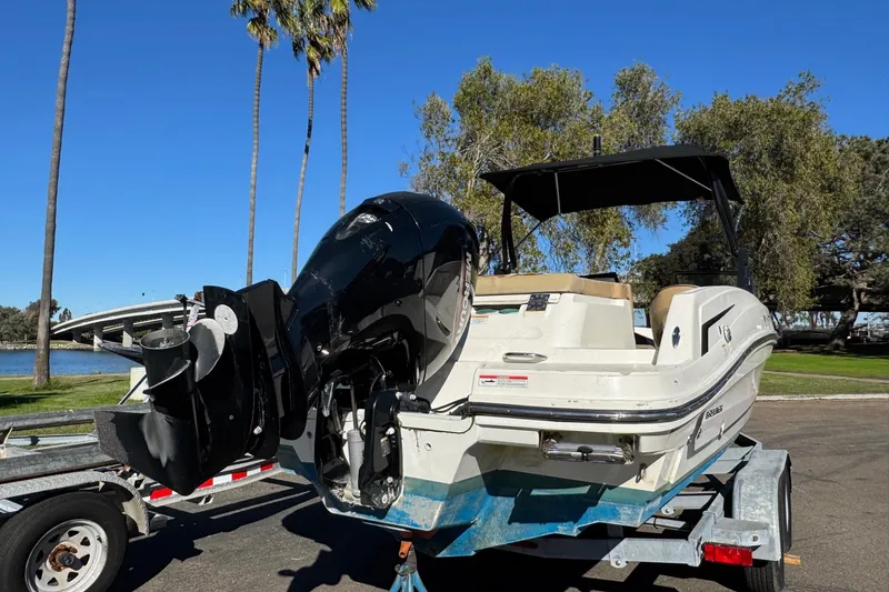 Slide: The Image of 2022 Bayliner VR6 Bowrider OB on trailer, parked near palm trees and water. - 16