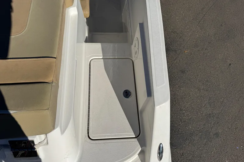Slide: The Image of 2022 Bayliner VR6 Bowrider OB interior with beige seating and storage compartment. - 21