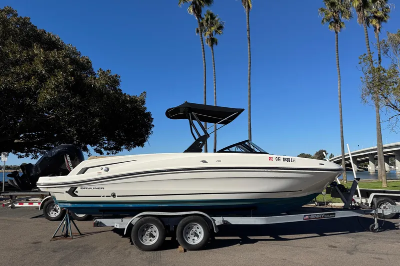 The Image of 2022 Bayliner VR6 Bowrider OB on trailer, parked near palm trees and water. - 5