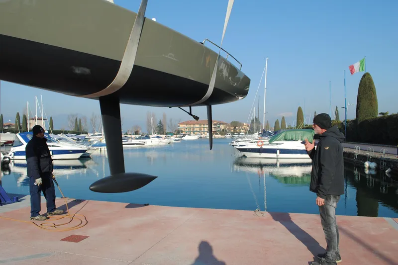 Slide: The Image of Men inspecting a 2026 Brenta 30 sailboat at a marina dock. - 12