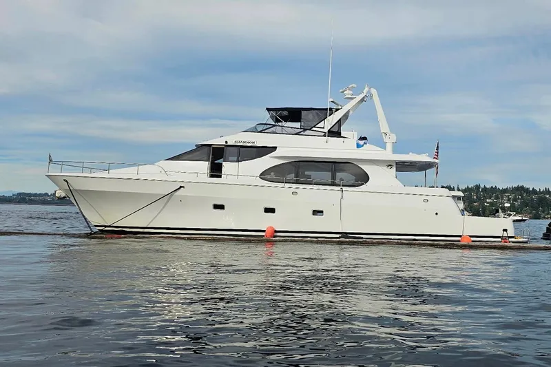 Slide: The Image of Custom 2000 motor yacht on calm water with scenic background. - 99