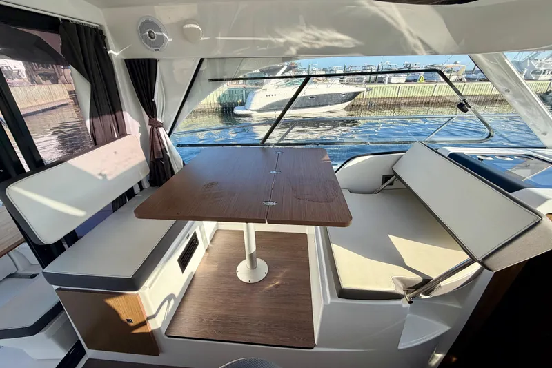 Slide: The Image of Interior of 2021 Beneteau Antares 9 boat with seating and table, dockside view. - 12