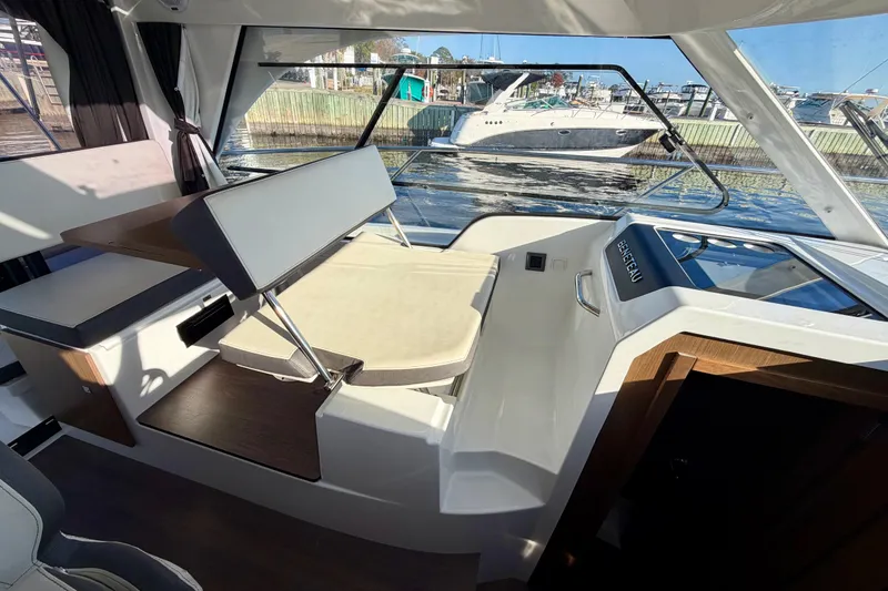 Slide: The Image of Interior view of 2021 Beneteau Antares 9 boat, featuring seating and table setup. - 13