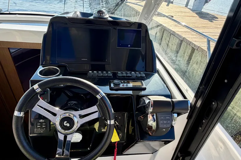 Slide: The Image of Helm of 2021 Beneteau Antares 9 with steering wheel and navigation screens. - 14