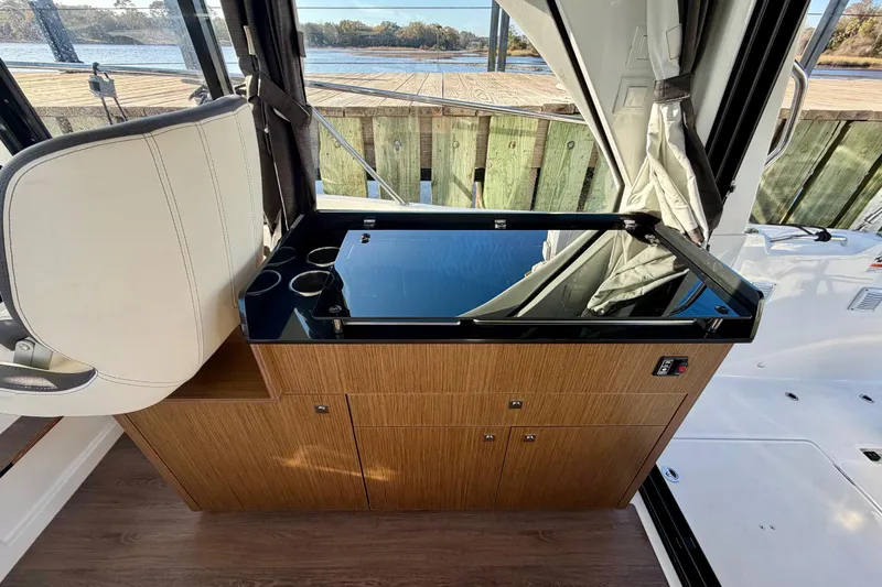Slide: The Image of Interior of 2021 Beneteau Antares 9 boat with wooden cabinetry and seating. - 16
