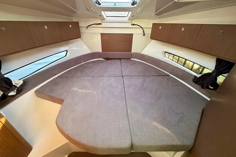 Slide: The Image of 2021 Beneteau Antares 9 cabin interior with cozy bed and wooden storage cabinets. - 18