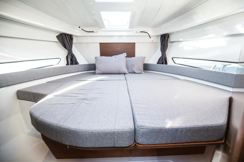 Slide: The Image of 2021 Beneteau Antares 9 motorboat cruising on a serene lake under a clear blue sky. - 5