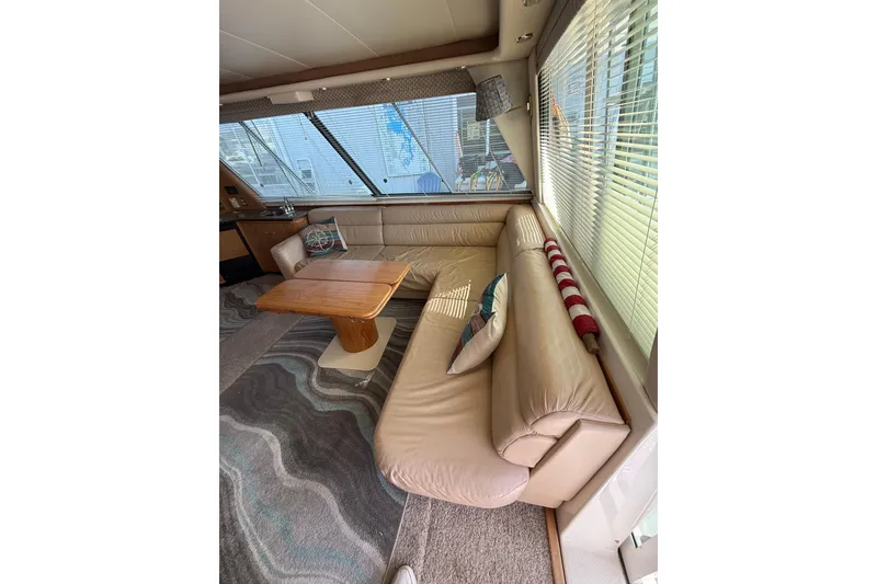 Slide: The Image of Luxurious interior of 1997 Bayliner 47 Motoryacht with leather seating and wooden table. - 13