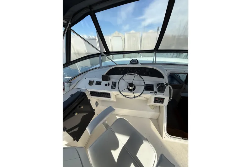 Slide: The Image of 1997 Bayliner 47 Motoryacht helm with steering wheel and control panel. - 2